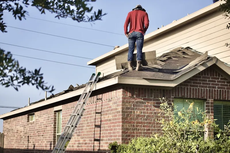 Professional roofer working on a residential roof in Becker